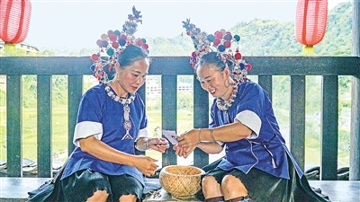     程陽橋上，侗族婦女在展示制作侗族刺繡產(chǎn)品。繡品圖案精美、色彩艷麗，成為當?shù)靥厣a(chǎn)業(yè)。